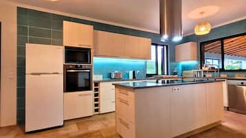 Cocina moderna con isla central, electrodomésticos integrados y vistas al exterior.