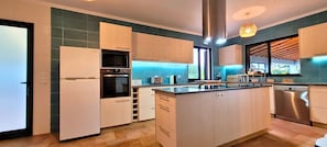 A modern kitchen with a central island, built-in appliances, and a view to the outdoors.