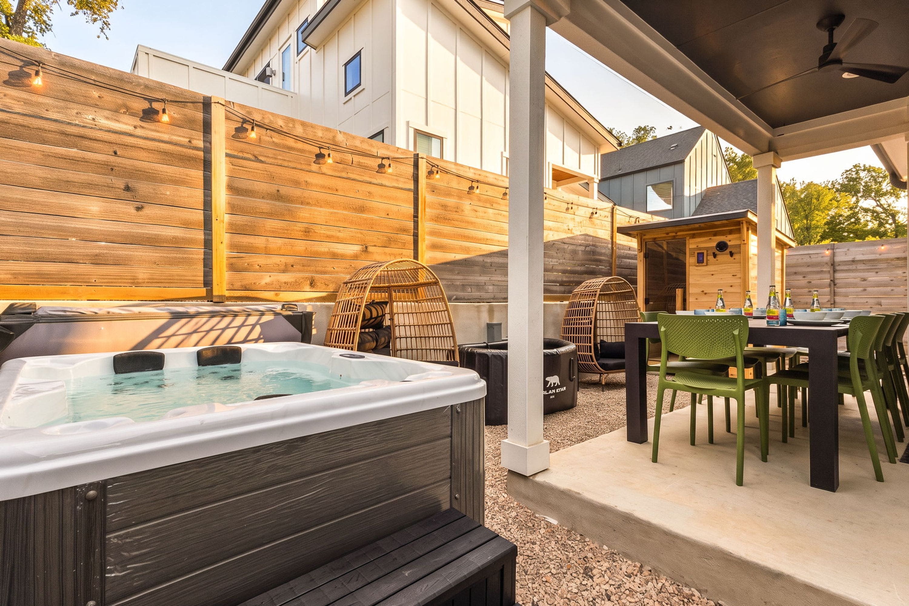 Un jacuzzi, zona de estar exterior y un patio cubierto.