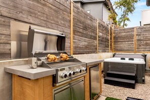 Eine Außenküche mit integriertem Grill, Backofen und Barbecue-Smoker.