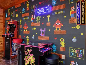 A retro arcade room with a neon 'GAME ON' sign, vintage arcade machines, and pixel art wall decorations. - Sleeps 28 Private Pool Hot Tub Game Room (Sevierville)