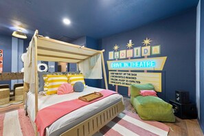 Ein Schlafzimmer mit Baldachinbett, einer Neonreklame und einer kleinen Sitzecke.