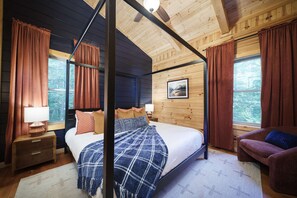 Un dormitorio con cama con dosel, paredes de madera y ventanas grandes con cortinas.