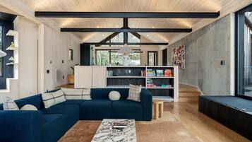 A modern living room with a sectional sofa, a marble coffee table, and a built-in bookshelf.