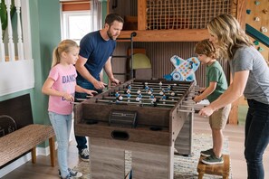 A room with a foosball table, a bunk bed, and a climbing wall. - 4BR Emerald Coast Escape Pool Hot Tub Theater (Fort Walton Beach)