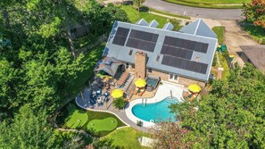 A modern building with a swimming pool, outdoor seating, and solar panels. - 4BR Emerald Coast Escape Pool Hot Tub Theater (Fort Walton Beach)