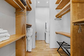 A narrow walk-in closet with wooden shelving, a hanging rack, and a white towel stack. - Blissful Bluff Mtn Views Fire Pit Sleeps 6 (Candler)