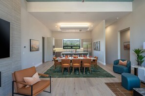 A modern interior with a dining area, kitchen, and seating space. - Bell Rock Hacienda Rooftop Deck Hot tub Sauna (Sedona)