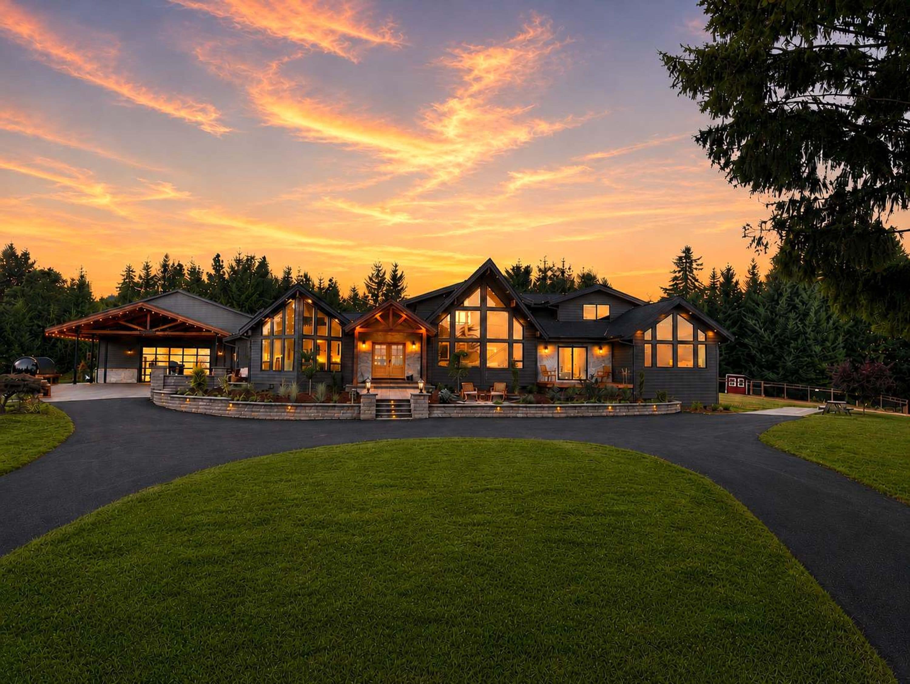 A modern two-story house with a covered patio and a well-maintained lawn.