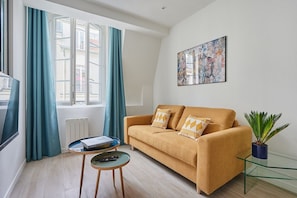 A modern living room with a sofa, a glass coffee table, and a potted plant. - Sublime  appartment  in center of Paris (Paris)