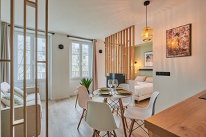 A modern interior with a dining area, a bed, and a living space. - Charming Studio Center of Paris-Montorgueil (Paris)