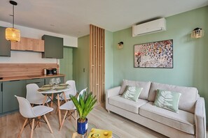 A modern living space with a dining area, a sofa, and a painting on the wall. - Charming Studio Center of Paris-Montorgueil (Paris)