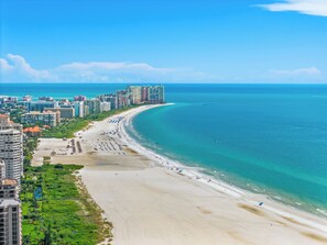 A coastal cityscape with a wide beach, high-rise buildings, and clear blue skies. - Luxe Waterfront 4 Bed Escape | Near Beach (Marco Island)