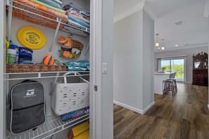 A neatly organized storage area with shelves, baskets, and a variety of items including a bag, a bottle, and a yellow object. - Waterfront Bonita Springs Retreat with Boat Dock & Estero Bay & Gulf Access (Bonita Springs)