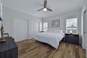 A bedroom with a bed, a nightstand, a ceiling fan, and a window with blinds. - Waterfront Bonita Springs Retreat with Boat Dock & Estero Bay & Gulf Access (Bonita Springs)