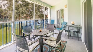 Ein Balkon mit Gartenmöbeln, einem kleinen Tisch und einer dekorativen Schale.
