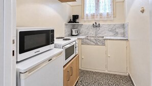 Cozinha compacta com micro-ondas, fogão e pia.