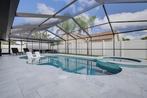 Una piscina dalla forma sinuosa, circondata da un portico coperto con sedie a sdraio.