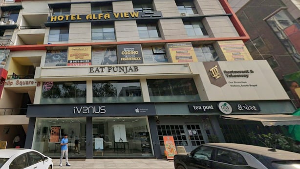 A multi-story building with a sign for Hotel Alfa View at the top. - Hotel Alfa View (Ahmedabad)