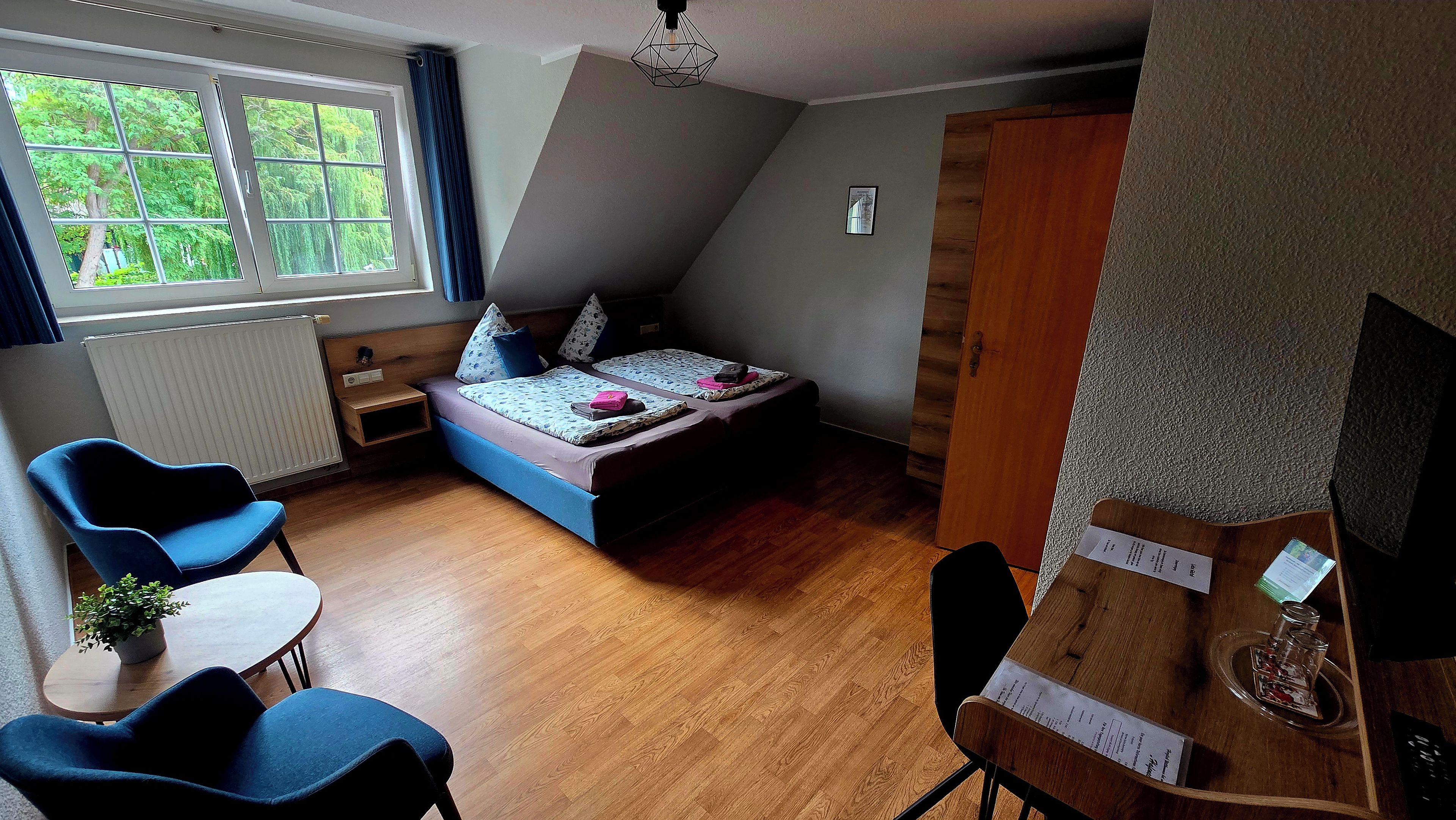 Una habitación pequeña con cama, escritorio y silla.