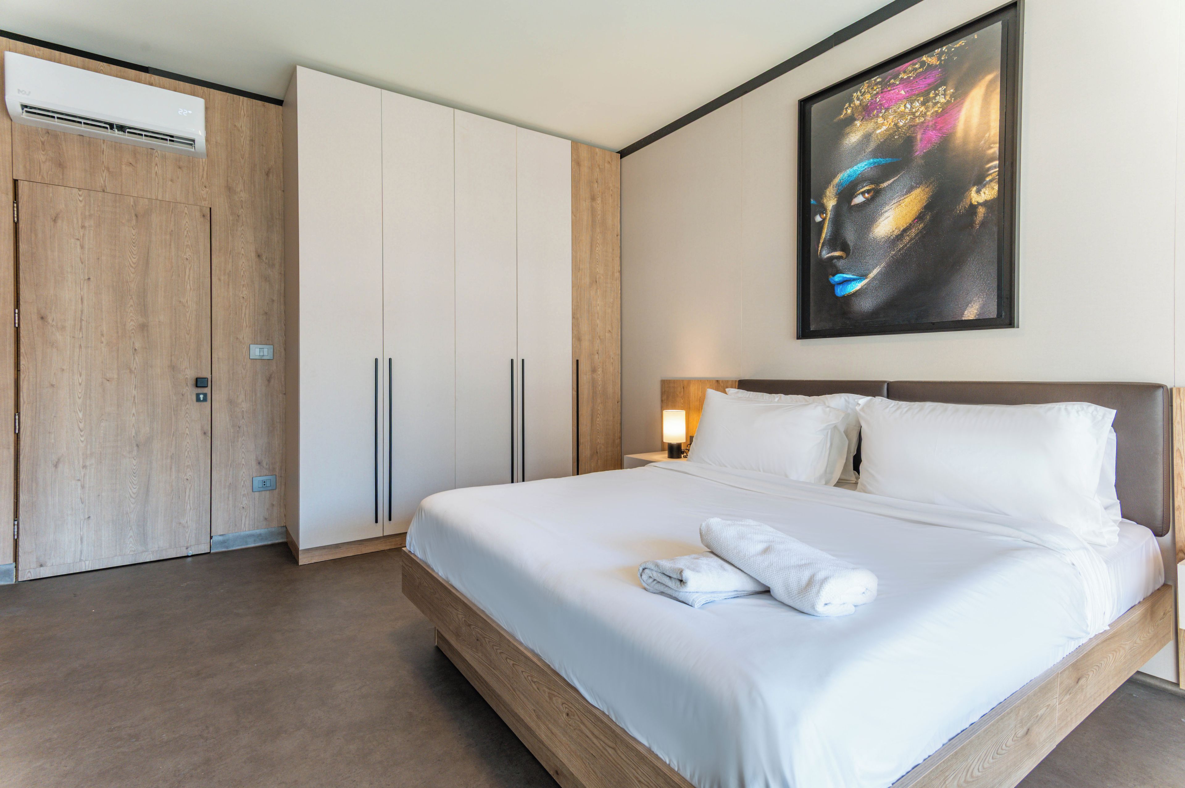 Ein Hotelzimmer mit einem großen Bett, einem Kleiderschrank und einem Bild an der Wand.