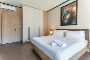 Una habitación de hotel con una cama grande, un armario y un cuadro en la pared.