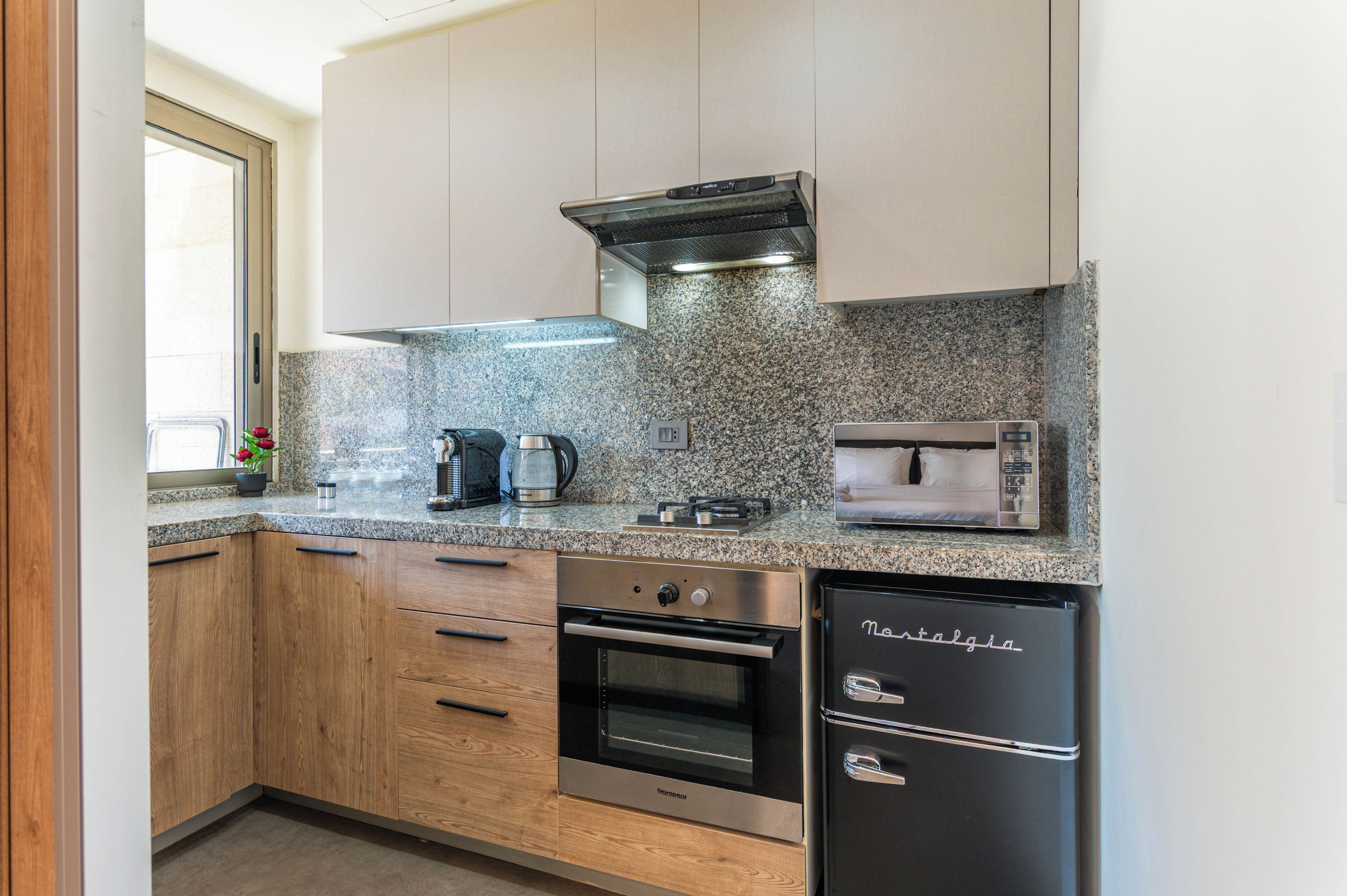 A modern kitchen with granite countertops, stainless steel appliances, and wooden cabinets.