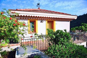 A small, single-story building with a red-tiled roof, a white facade, and a small porch area. - Farmhouse with panoramic swimming pool in Gioiosa Marea (Gioiosa Marea)