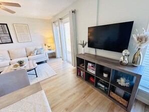 Una sala de estar moderna con sofá, mesa de centro y mueble para televisión.