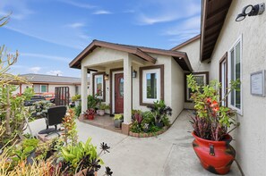 A residential building with a covered porch, potted plants, and a clear sky. - Coastal Get-away In San Diego Near Imperial Beach 2 Bedroom Home (San Diego)