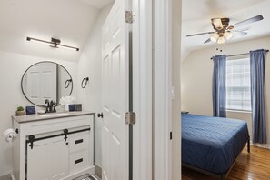 A bedroom with a bed, a ceiling fan, and a window with curtains. - Little River Lodge 5 Bedroom Cabin (Sevierville)