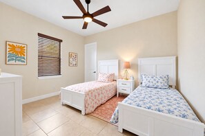 A bedroom with two beds, a ceiling fan, a window with blinds, and artwork on the walls. - Pin1362 3 Bedroom Home (Punta Gorda)