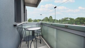 A balcony with a glass railing, a table, and two chairs. - Wroclaw | Zwycięska 3 | Comfortable Apartment | Air conditioning (Wrocław)