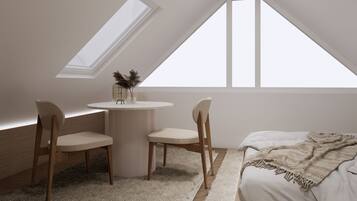 Ein Schlafzimmer mit einem Bett, einem runden Tisch, zwei Stühlen und einem Oberlicht.