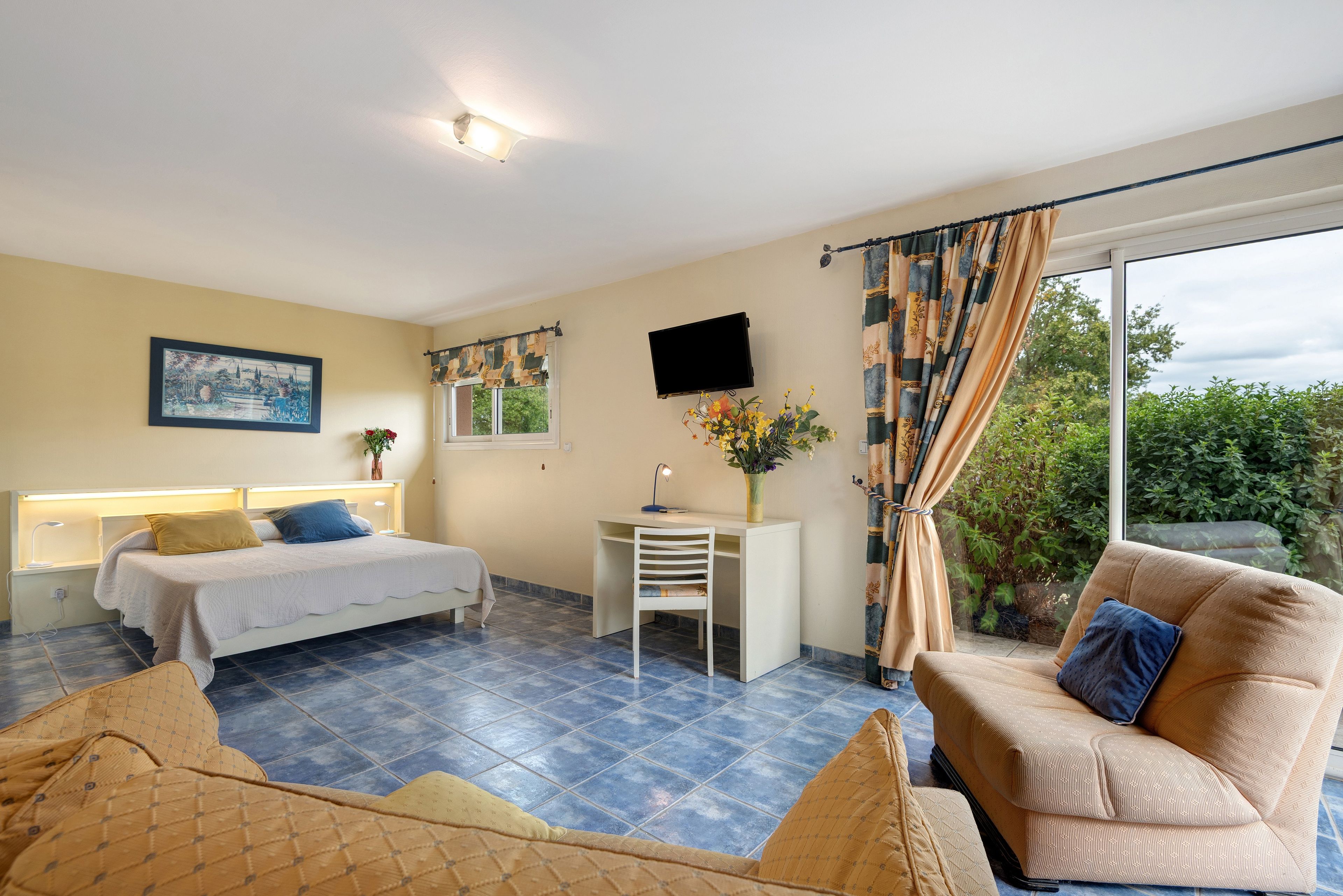 Une chambre d’hôtel comprenant un lit, un bureau et un coin salon.