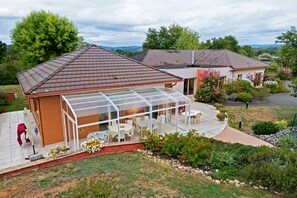 A residential property with a covered patio area, a swimming pool, and a well-maintained garden. - Bed and Breakfast 'La Coloniale - Prune' with Private Pool, Wi-Fi and Air Conditioning (Varetz)