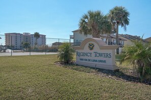 A sign for Regency Towers at 1600 Via de Luna Drive, featuring a clear view of the building and surrounding area. - 🐾 Regency Towers 808W | Pet Friendly Gulf Front | 3BR + Snorkeling Reefs (Pensacola Beach)