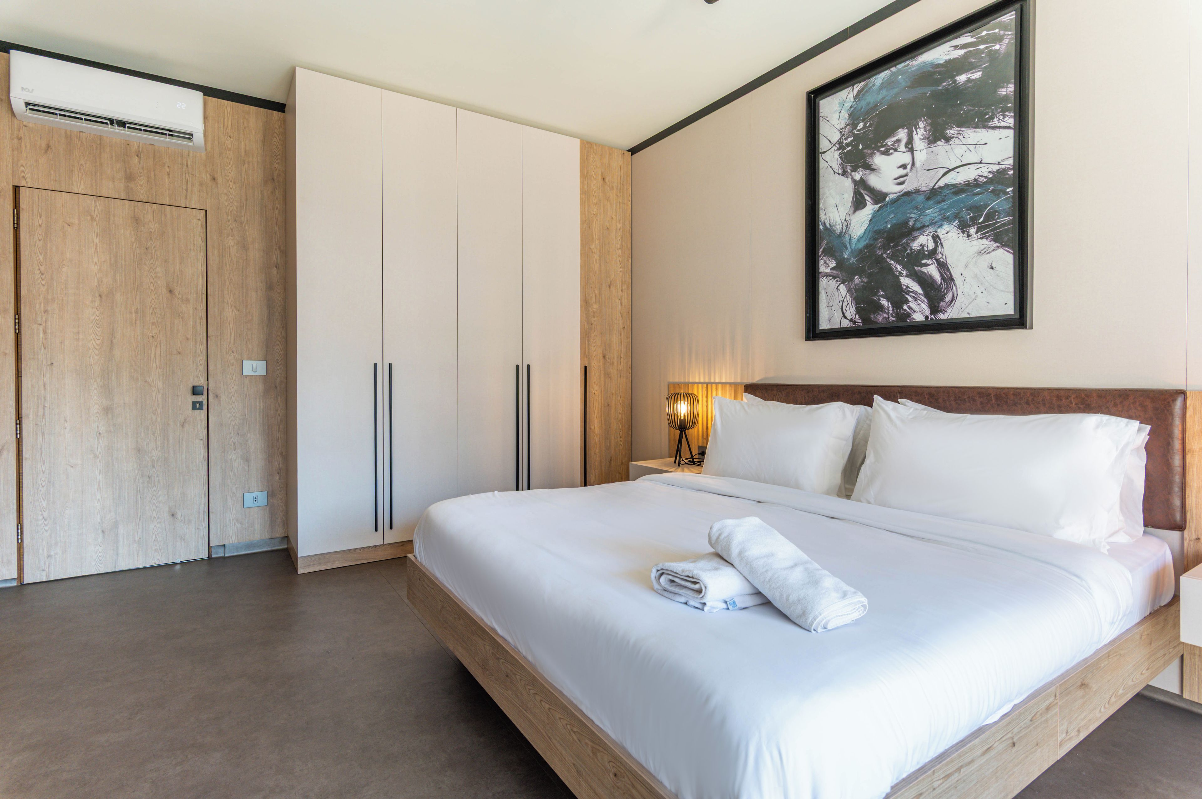 Ein Hotelzimmer mit einem großen Bett, einem Kleiderschrank und einem Gemälde an der Wand.