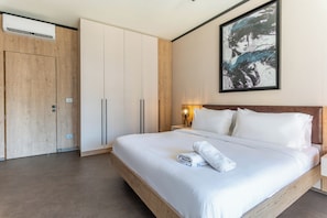 A hotel room with a large bed, a wardrobe, and a painting on the wall. - Elara Studio & Balcony in Jounieh (Jounieh)