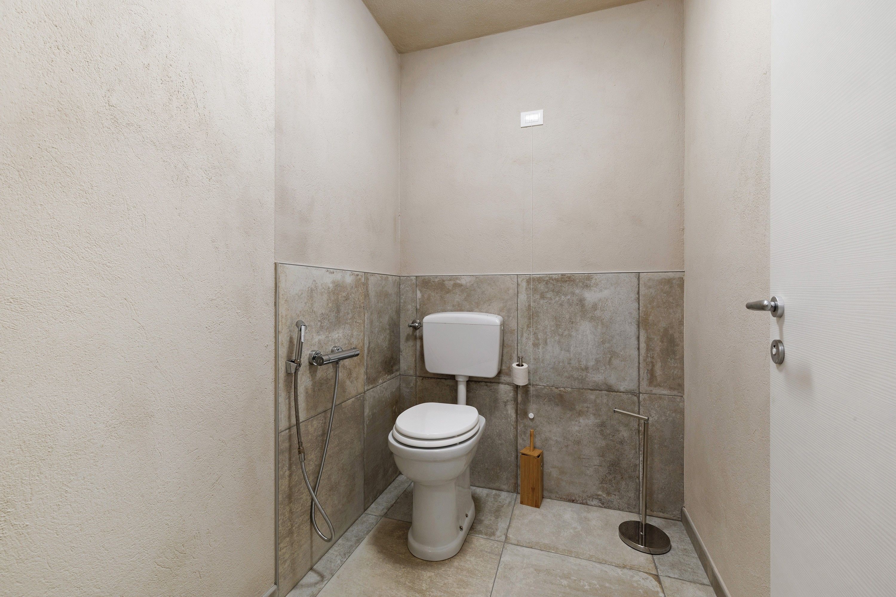 Un bagno piccolo e chiuso con un water, un bidet e una doccia.