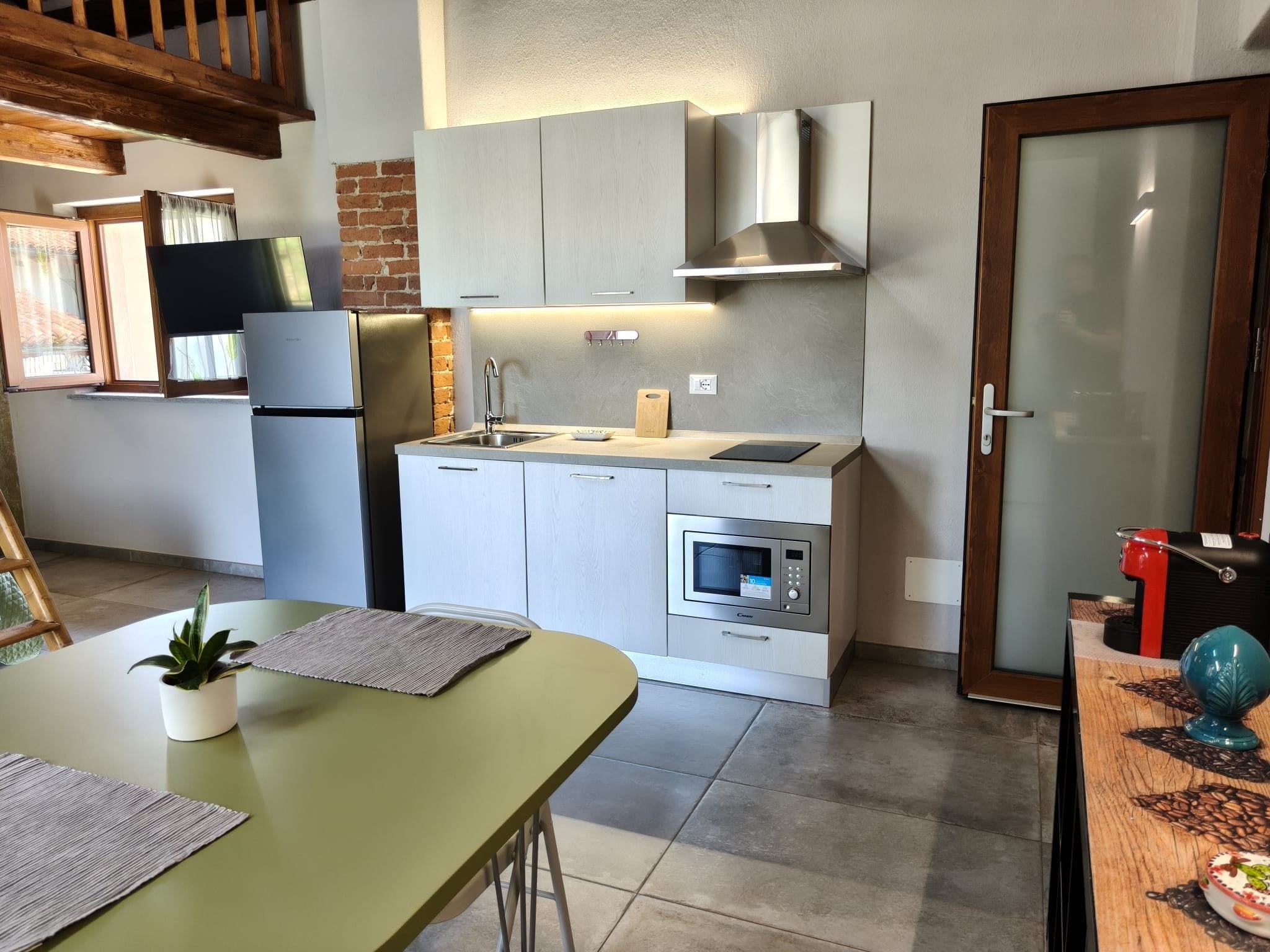 A compact kitchen with a refrigerator, oven, and a sink.