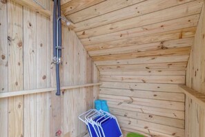 A wooden interior with a sloped ceiling, a metal pipe, and a blue folding chair. - Beautiful 3 Bedroom 2 full bath overlooking Sandlapper lake site S2 Ocean Lakes (Myrtle Beach)