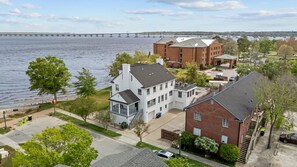 A residential area with a river, a bridge, and a hotel with a brick facade. - Waterfront Porch Escape (New Bern)