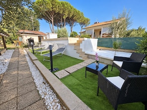 A patio area with outdoor furniture, a small pool, and a staircase leading to a covered deck.