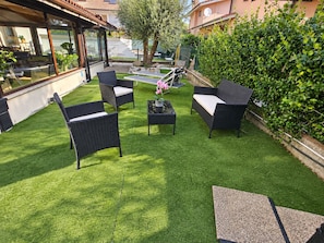 An outdoor seating area with wicker furniture and artificial grass.