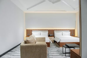 A modern hotel room with two beds, a sofa, a small table, and a nightstand.