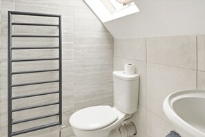 Un bagno con il water, una doccia e un lavandino.
