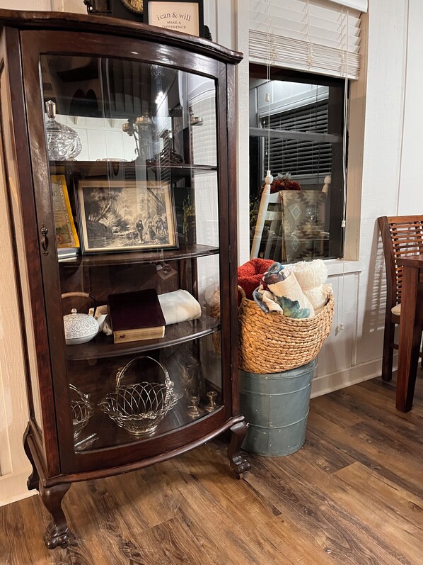 A wooden cabinet with glass doors containing various items.