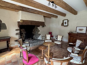 A rustic interior with a stone fireplace, wooden beams, and traditional furniture.