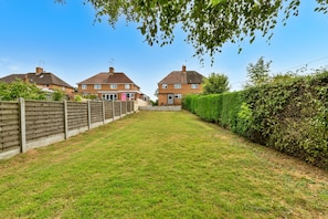 A residential area with two brick houses, a wooden fence, and a well-maintained lawn. - Mill House, Staffordshire (Stafford)